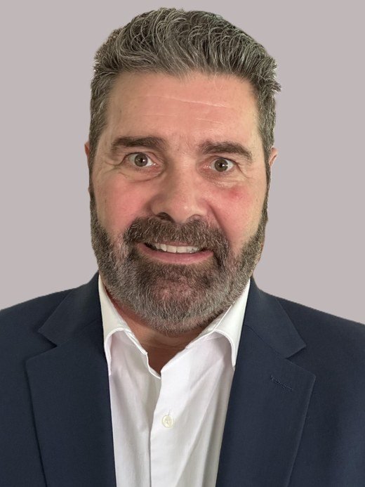 Portrait of Brian La Dieu in a navy suit and white shirt